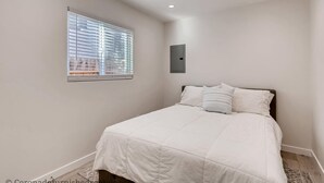 Una camera da letto con un letto, una finestra e un lampadario a parete.