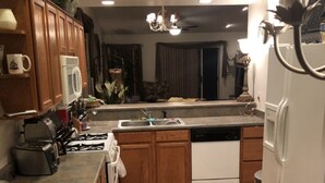 A kitchen with wooden cabinets, a white dishwasher, and a gas stove.