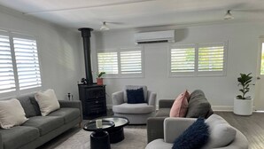 Ein modernes Wohnzimmer mit Kamin, zwei Sofas, einem Couchtisch und einer Topfpflanze.
