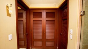 A hallway with double doors, a tiled floor, and a light switch on the wall. - Ocean View Suites to Accommodate Any Party Size On the Beach (Cabo San Lucas)