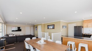Un espacio habitable compacto con comedor, kitchenette y sofá en la sala.