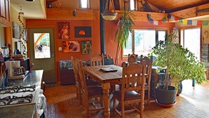 Een houten eettafel met stoelen, een potplant en een fornuis in een gezellig keukenhoekje.