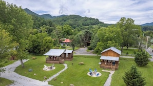 A lodge with two cabins, a covered seating area, and a gravel path.