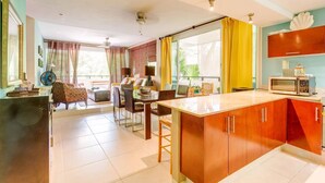 Una cocina moderna con armarios de madera, un microondas y un comedor con mesa y sillas.