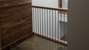 A corner of a room with a wooden panel wall and a white wall with a window. - Heart of RVA Arts District Walk to VCU, MCV, The National, Quirk Prime Downtown (Richmond)