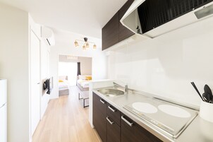 Una cocina moderna con un lavamanos doble, armarios oscuros y encimera blanca.