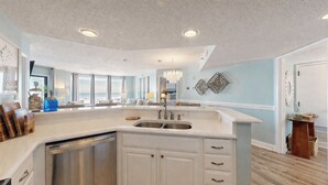 A spacious kitchen with a large island, a dishwasher, and a view of the ocean. - 3133 Villamare - Direct Oceanfront Views! (Hilton Head)