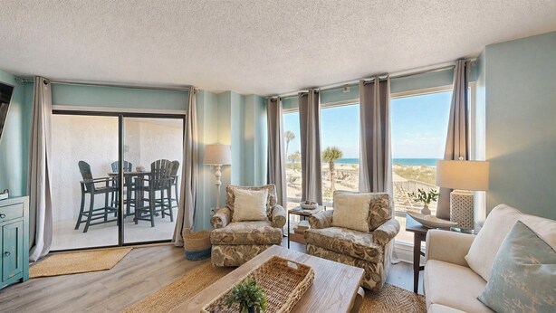A room with a view of the beach, a dining area with chairs, and a sofa. - 3133 Villamare - Direct Oceanfront Views! (Hilton Head)