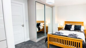 A hotel room with a bed, bedside tables with lamps, a wardrobe, and a sliding door. - New Modern Build on Muckross Road, Killarney, Kerry (Killarney)