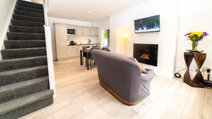 A modern living room with a grey sofa, a fireplace, and a TV mounted on the wall. - New Modern Build on Muckross Road, Killarney, Kerry (Killarney)