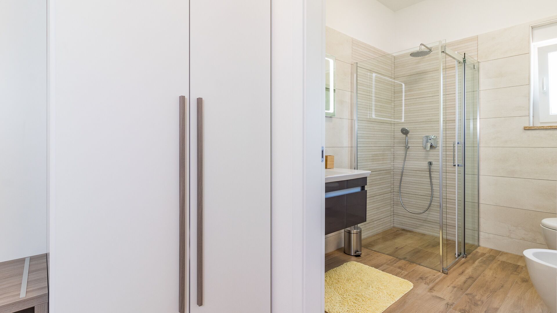 Une salle de bain moderne avec une douche à parois de verre, des toilettes et un lavabo.
