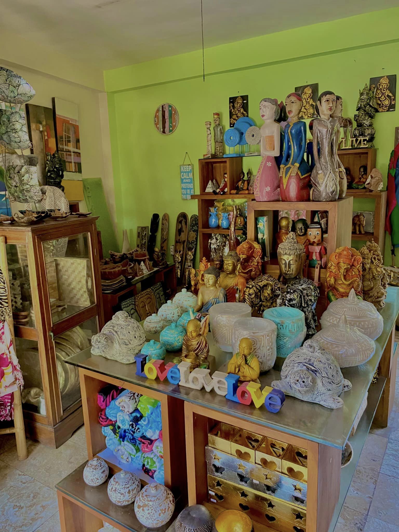 A room with a variety of decorative items including statues, vases, and figurines arranged on shelves and tables.