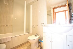 A bathroom with a bathtub, toilet, and sink. - 6th floor, front line facing the Mediterranean (La Manga del Mar Menor)