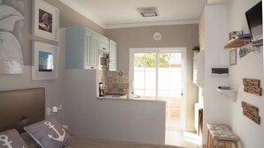 A bedroom with a bed, pillows, a nightstand, and a wall-mounted TV. - The best solution for couples in love (Maspalomas)