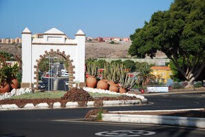 A roundabout with a central monument featuring a brick archway and a white structure with a pointed roof.