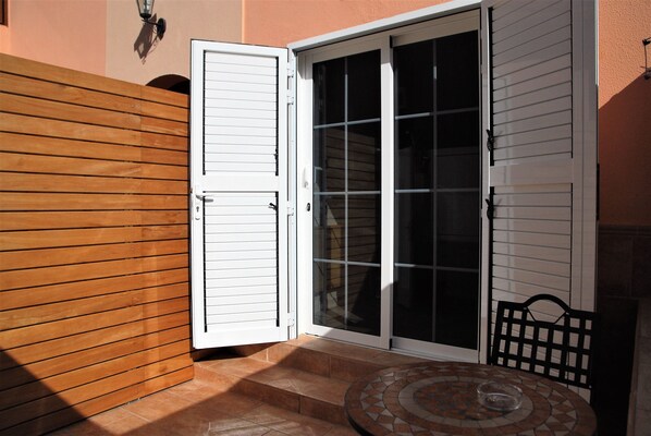 A patio with a tiled table and a wooden fence.