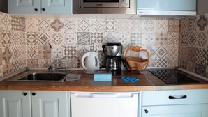 A kitchen with a microwave, kettle, coffee maker, and a tea box on the counter. - The best solution for couples in love (Maspalomas)