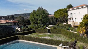 Un espace piscine offrant une vue dégagée sur le paysage environnant, notamment sur les arbres et les bâtiments.