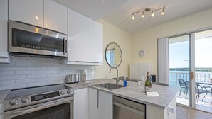 A modern kitchen with a built-in oven, microwave, and a large island with a sink.