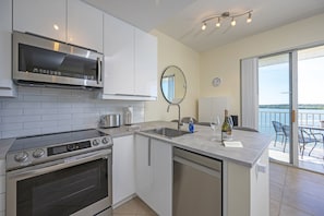 A modern kitchen with a built-in oven, microwave, and a large island with a sink.