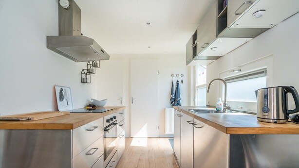 A modern kitchen with stainless steel appliances, wooden countertops, and a view of the outdoors. - Modern chalet situated on the edge of the park. This chalet has much to offer for both adults and ch (Burgh-Haamstede)