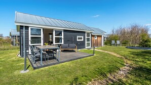 A modern house with a deck, a patio, and a small garden. - Modern chalet situated on the edge of the park. This chalet has much to offer for both adults and ch (Burgh-Haamstede)