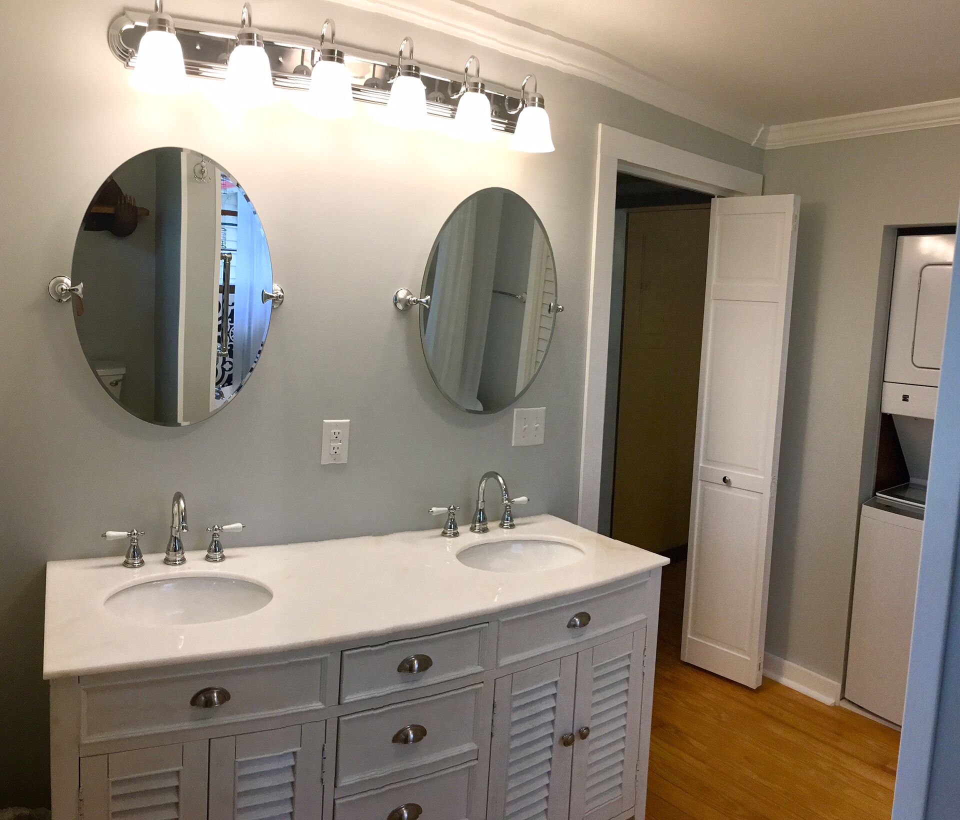 Un baño con dos lavamanos, un espejo y un mueble blanco con cajones.