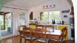 Une cuisine avec une table à manger et des chaises, une fenêtre et un évier.