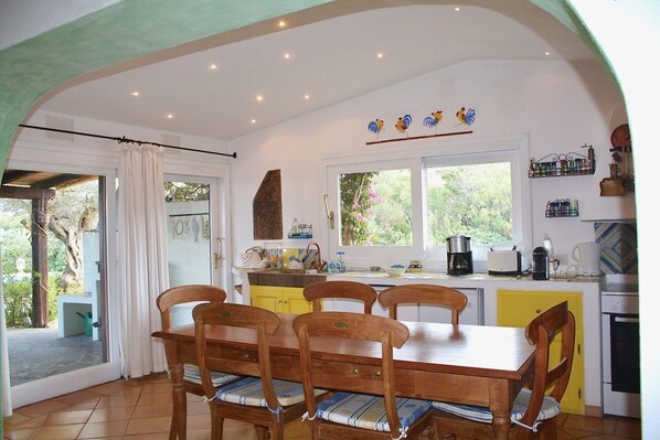 A kitchen with a dining table and chairs, a window, and a sink.