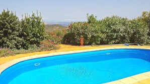 Une piscine entourée d’une végétation luxuriante, offrant une vue dégagée sur le paysage.