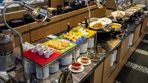 Una mesa de buffet con diferentes tipos de comida y utensilios.