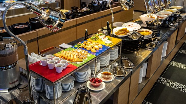 Una mesa de buffet con diferentes tipos de comida y utensilios.