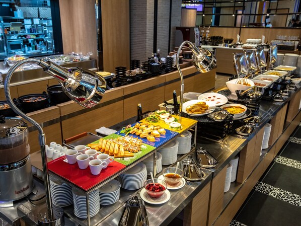 A buffet setup with various food items and serving utensils.