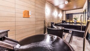 Un moderno espacio de spa con un jacuzzi grande, paredes de paneles de madera y un mostrador con lavabo.