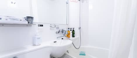 Un baño moderno con un lavabo blanco, un espejo, una ducha y un inodoro. Hay artículos de aseo en la encimera del lavabo.