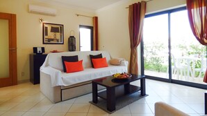 A living room with a sofa, a coffee table, and a view of the outdoors. - 2 Bed House, Pera,  Nr. Albufeira, Algarve. - Shared Pool (PERA)