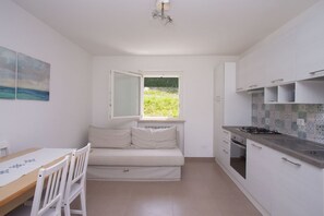 Una cocina compacta con comedor, un ventanal con vistas y un pequeño sofá.