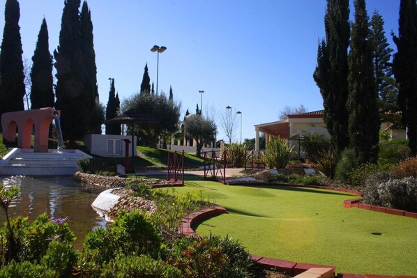 A well-maintained garden with a pond, a gazebo, and a lawn.