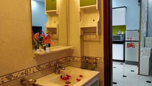 Casa de banho com lavatório, espelho e espelho com moldura verde.