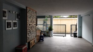 Um quarto amplo com teto baixo, um armário de madeira, uma planta em vaso e um portão que dá para o exterior.