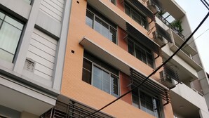 Um edifício residencial com vários andares, varandas, janelas amplas e um design arquitetônico moderno.