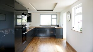 Una cucina moderna con un'ampia finestra, elettrodomestici integrati e pavimento in legno.