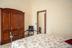 Une chambre à coucher avec un lit, une armoire en bois et un miroir.