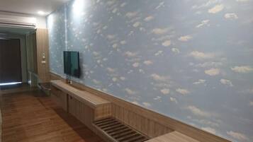 Un pasillo con un banco de madera, una escalera y un muro con diseño de nubes.