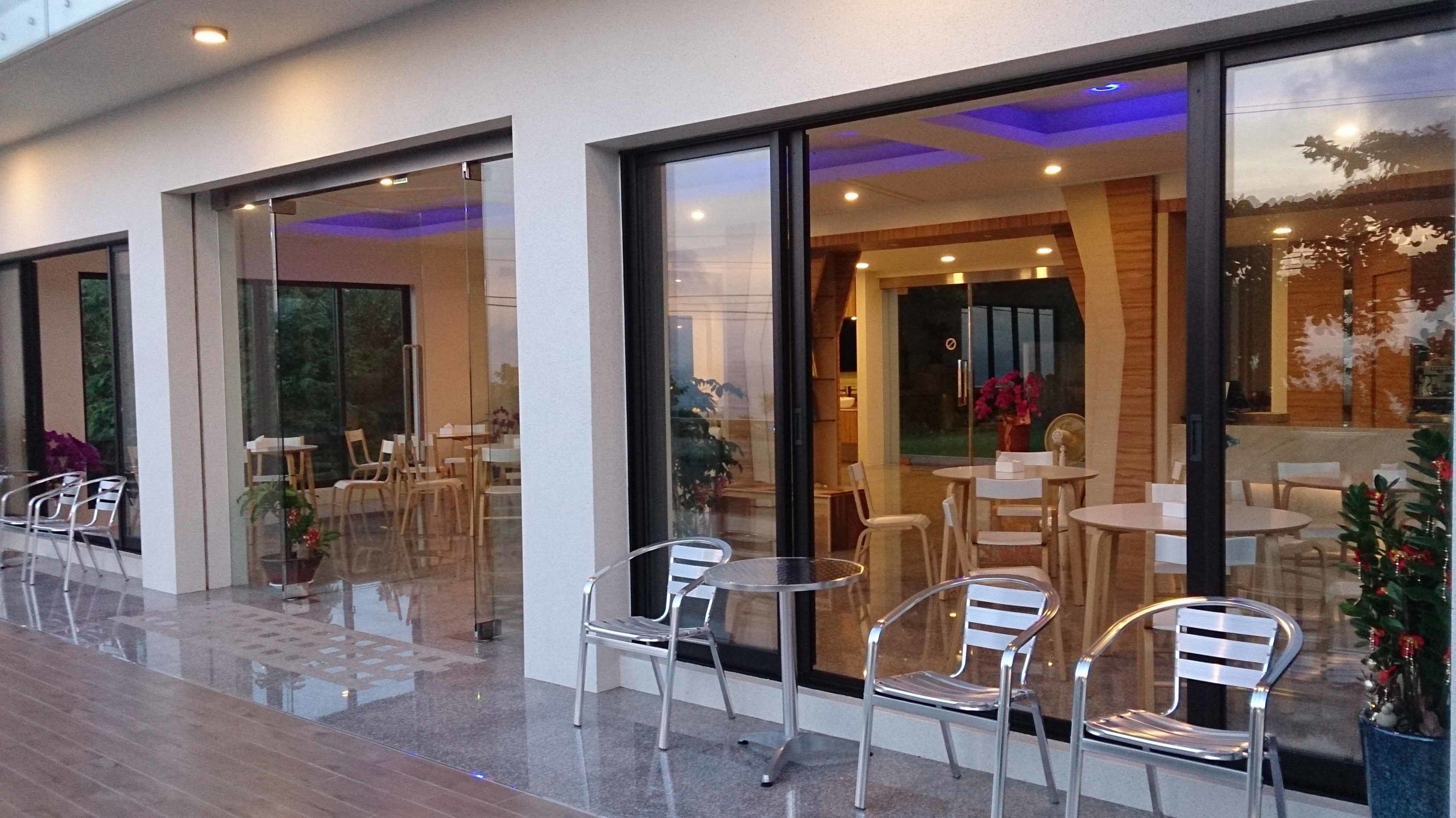 Un área de estar al aire libre con puertas de cristal que dan a un restaurante.