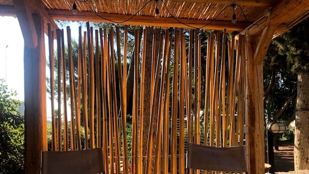 A covered outdoor seating area with bamboo partitions and a wooden deck. - House 34 - The Bougainvillea (Ceglie Messapica)