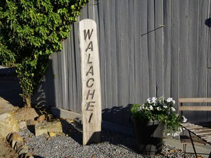 Uma placa de madeira com o nome "WALACHE" fixada em um poste.