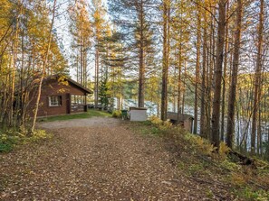 A cabin with a gravel driveway leading to a dock by a lake, surrounded by trees. - Aurinkorinne by Interhome (Punkaharju)