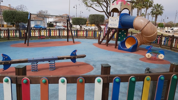 A playground with a seesaw, a slide, and a climbing structure. - Villa With private pool, Air Con and WiFi on an 18 hole secure golf course. (Torre-Pacheco)