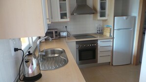 A modern kitchen with stainless steel appliances, a built-in oven, and a sink.